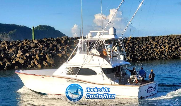 White 50 foot Maverick sportfishing yacht cruising past a rocky breakwater